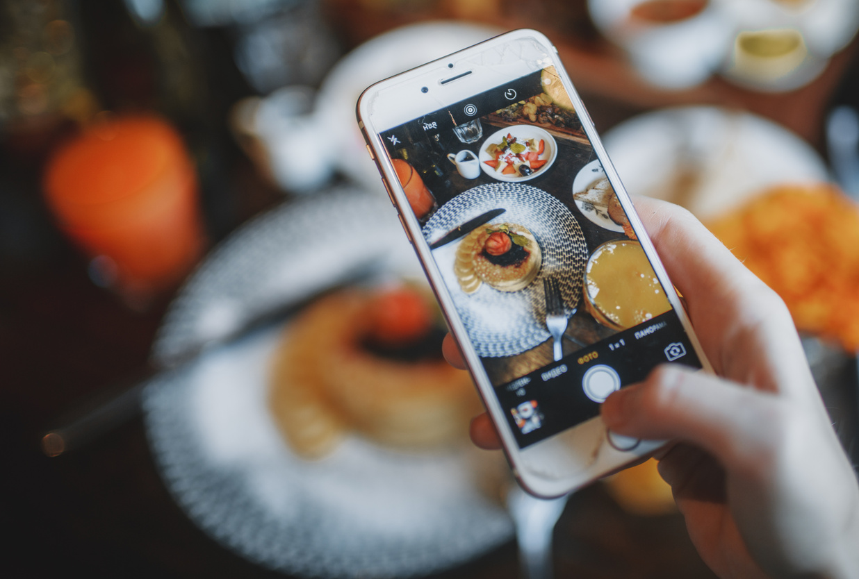 Crop person taking photo of food on smartphone of food